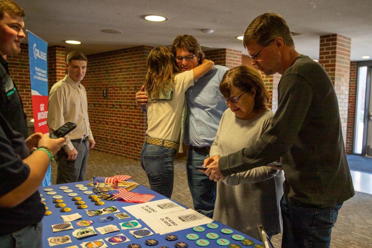 Mason Fouquet, treasurer of Turning Point USA at Wichita State,  hugs his mother as his father and grandmother check in to the event.