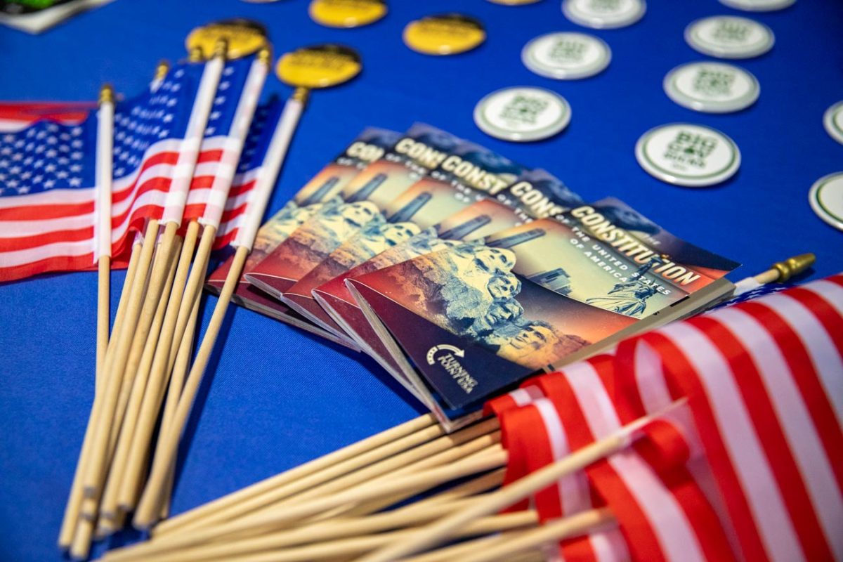 The U.S. flag and copies of the constitution are displayed alongside stickers at the event hosted by Turning Point USA at Wichita State.
