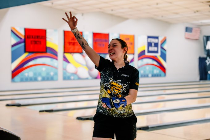Wichita State women's bowler Aleesha Oden holds up three fingers after rolling a turkey. (Photo courtesy of Bryan Chavez / Wichita State Athletics)