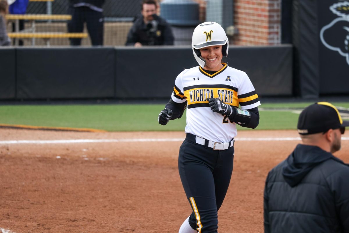 Graduate student Lauren Lucas smiles while jogging to first base. Lucas was walked in all four of her plate appearances.