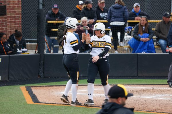 Senior Krystin Nelson high-fives junior Sami Hood after scoring a run on March 2. Nelson crossed the plate twice in the 6-4 loss.