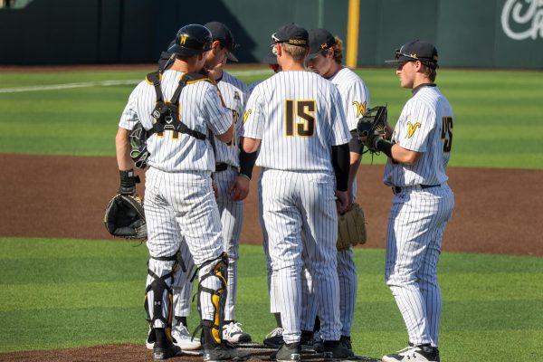 WSU pitching coach Anthony Claggett meets with the entire infield during a mound visit on March 1. Claggett is in his second year coaching for the Shockers.