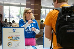 AFT Kansas Director of Member Services Amy Jensen gives a banana sticker to Joe Hanford. Jensen and other member passed out banana stickers to passersby in the Rhatigan Student Center, asking them to show their support for the union's request for increased wages.