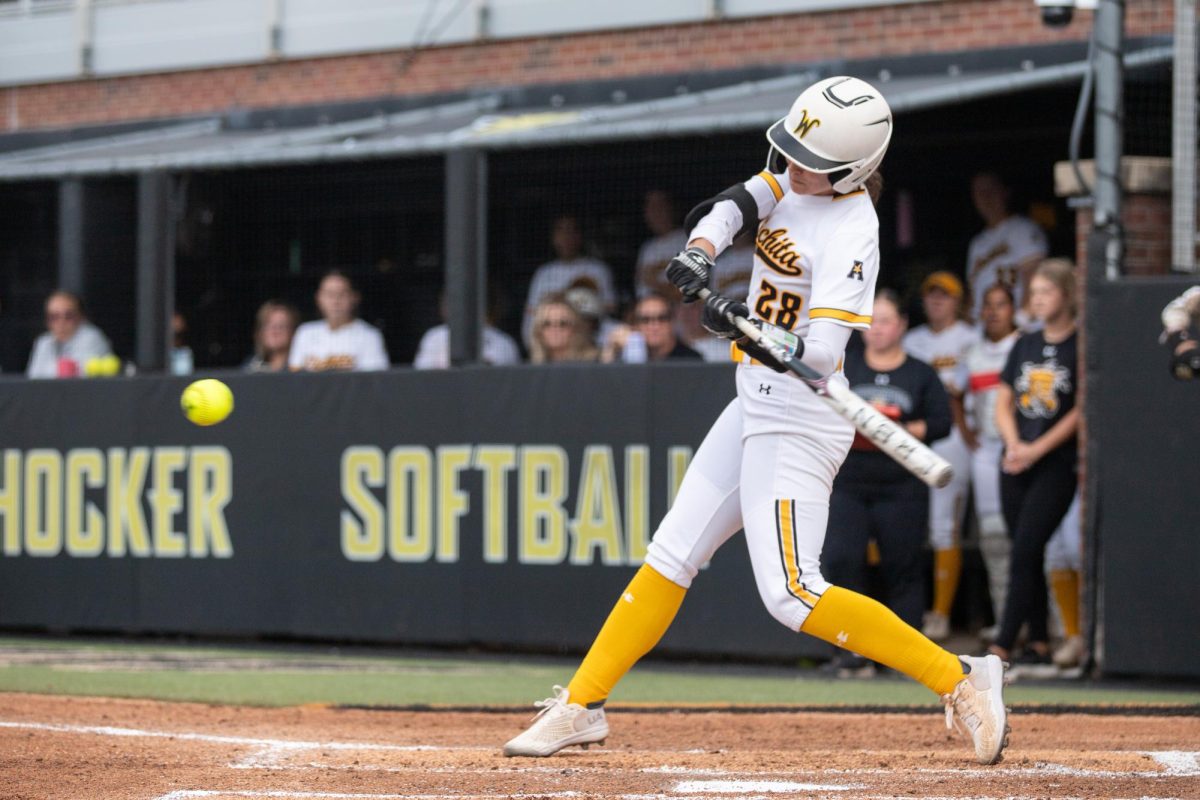 Graduate student Lauren Lucas readies up to hit the ball back during a game against the University of Kansas. The Shockers dropped the game, 5-3, after going two extra innings.