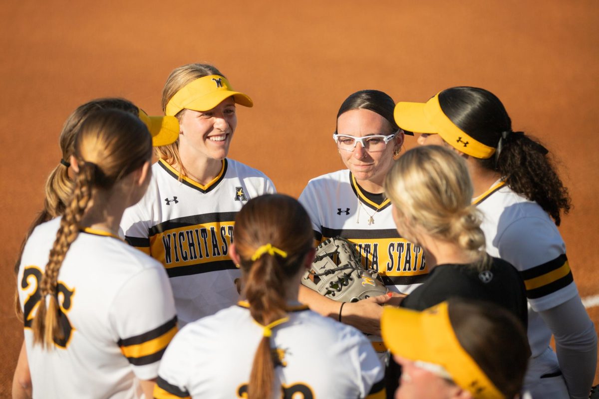 Before the start of the match against East Carolina University, members of the Wichita State softball team form a circle and play a warmup game. The Shockers run-ruled the Pirates in a 11-2 win on April 11.