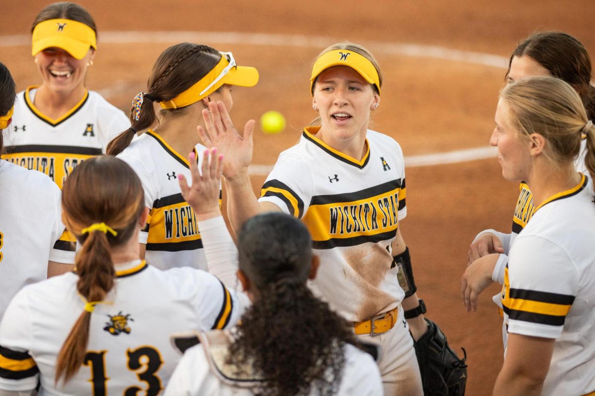 Senior Krystin Nelson high fives freshman Ryley Nihart after a run-rule in the top of the fifth inning against East Carolina. The Shockers won, 11-2.