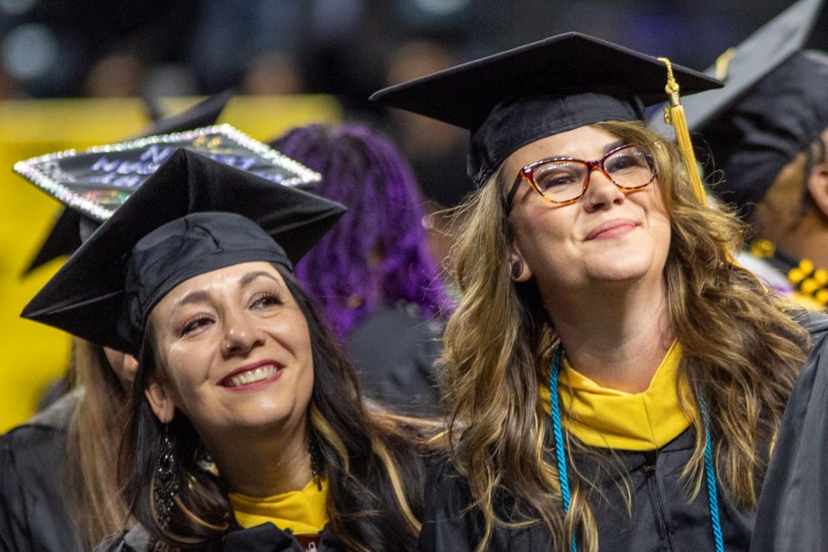 Students smile together while looking at the crowd at the commencement ceremony on May 16.