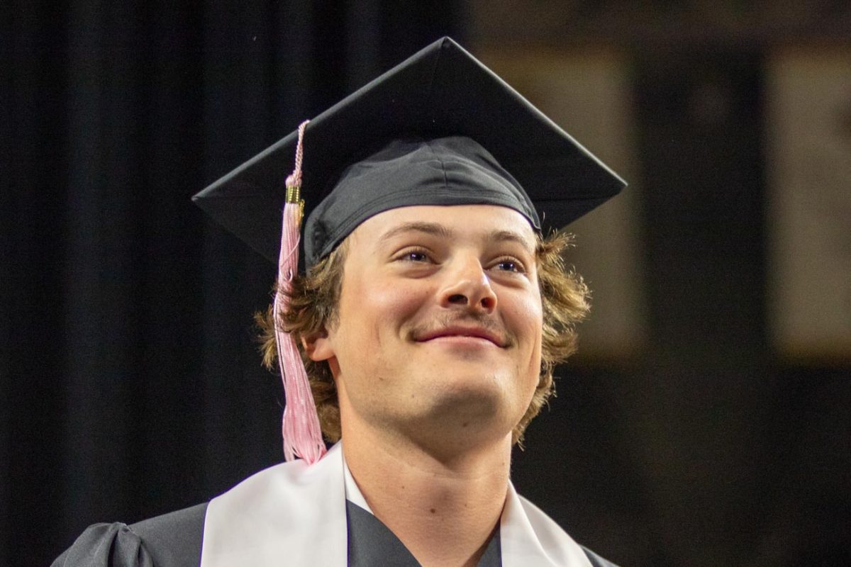 Student smiles at the crowd after recieving diploma om May 17.