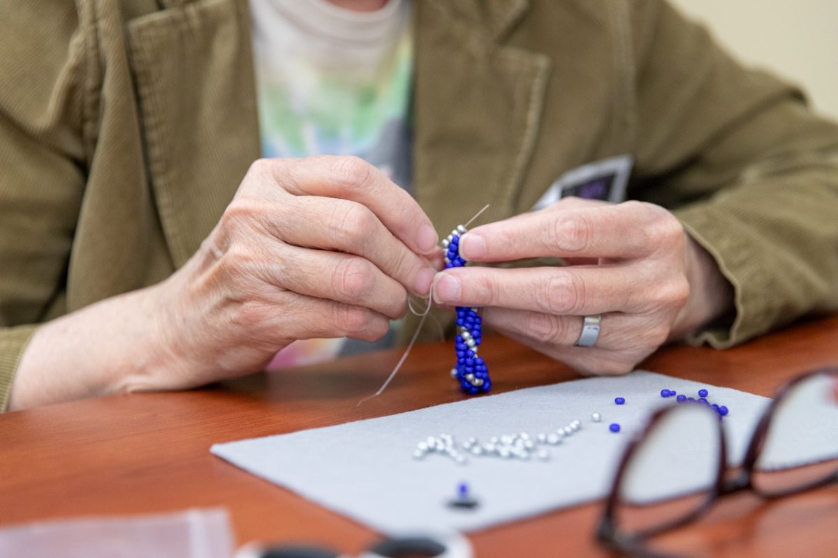 Biological sciences Office Coordinator Marcia Norton adds another stitch to her spiral bracelet. Norton and her friend, professor Moira Beck, enjoy crafting together.