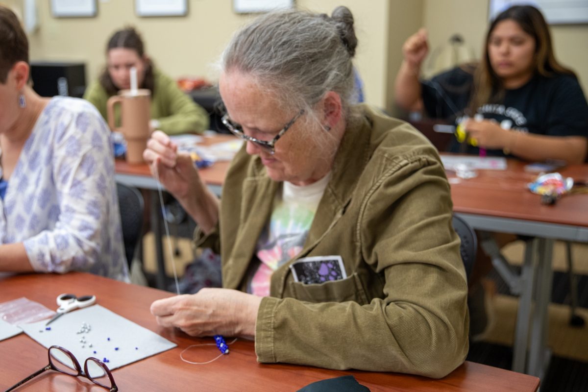 Biological sciences Office Coordinator Marcia Norton adds another stitch to her spiral bracelet. Norton and her friend, professor Moira Beck, enjoy crafting together.