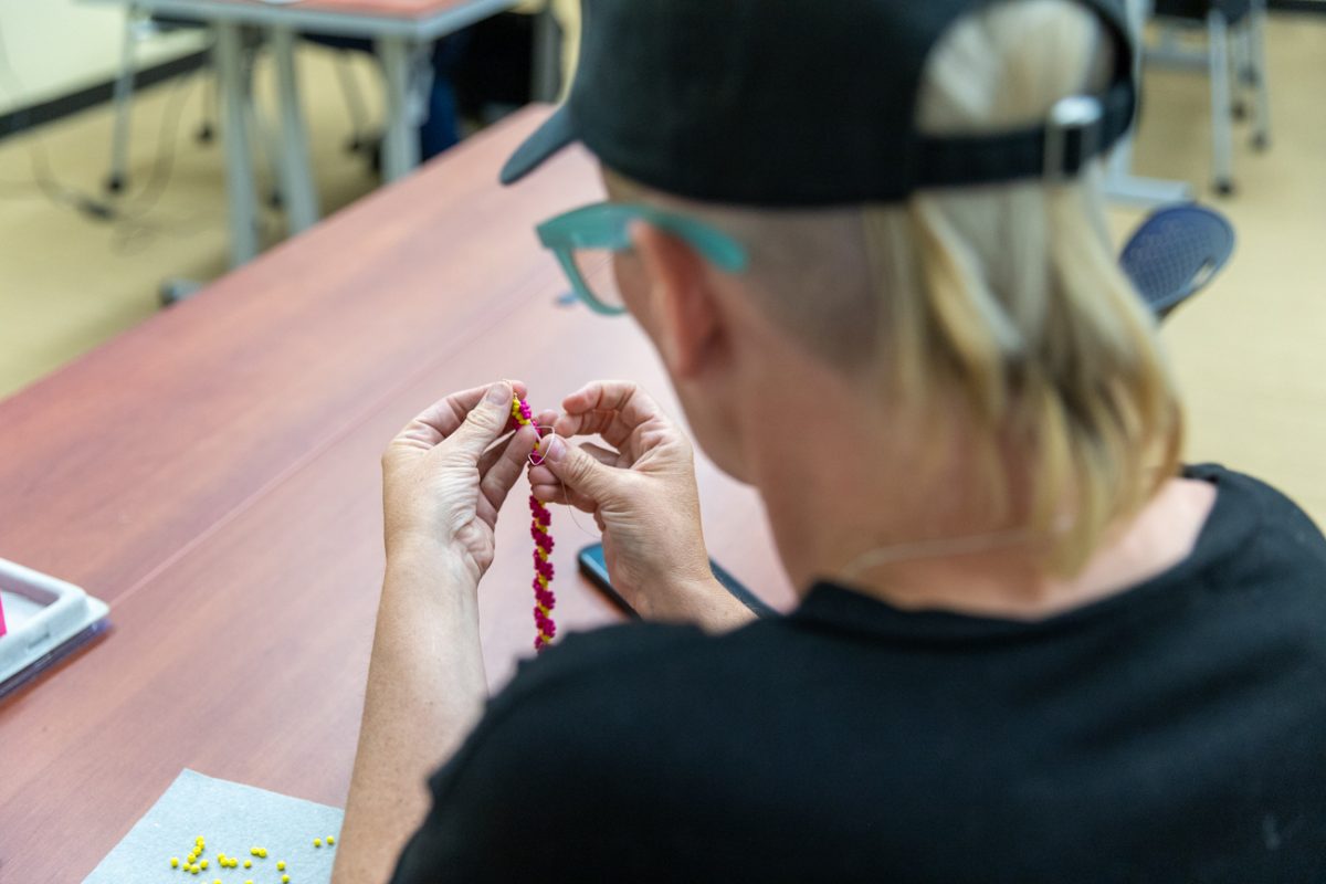 Holly Byers, a Choctaw and Chickasaw Nation community member, adds a stitch to her spirial stitch bracelet. Byers took up beading to reconnect with her culture and to maintain sobriety. "I bead to stay sober," Byers said.