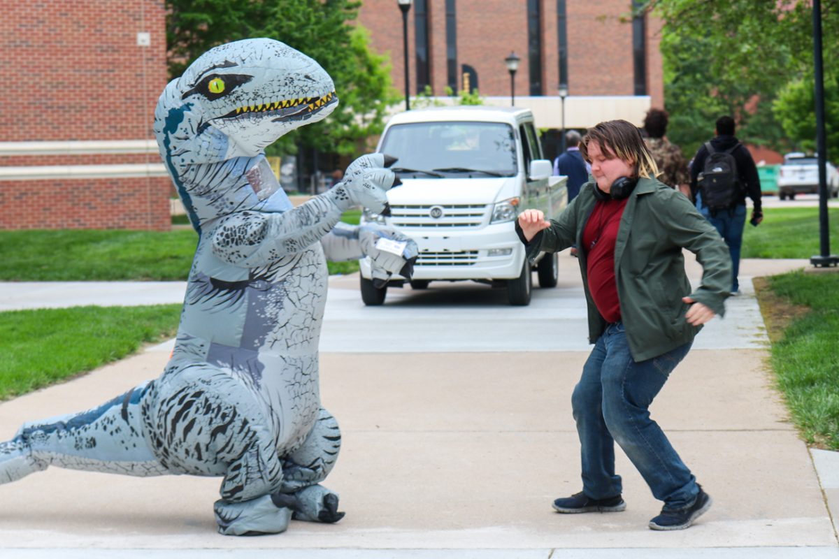 Sara Leftwich, a program specialist with the Shocker Career Accelerator, dances with history student Wyatt Barmann during the Prehistoric Pep Rally outside of Ablah Library. Leftwich, dressed in an inflatable dinosaur costume, boogied with other support service staff and paraded around campus on May 6 to motivate students ahead of finals week.