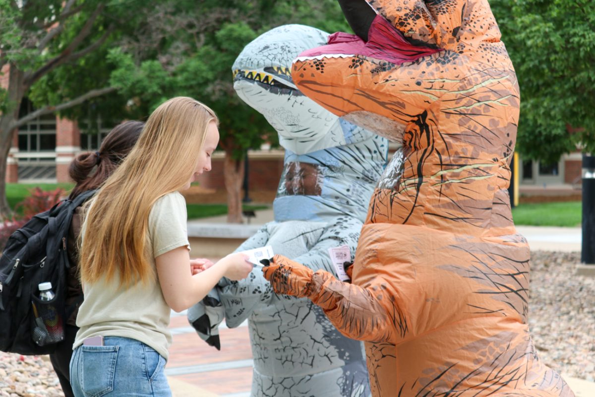 Two freshmen accept affirmation and motivation cards from Ablah Library and Student Success services staff during the Prehistoric Pep Rally on May 6. The pop-up event was held outside Ablah Library and around the Student Success Center to encourage students and wish them luck ahead of final exams.