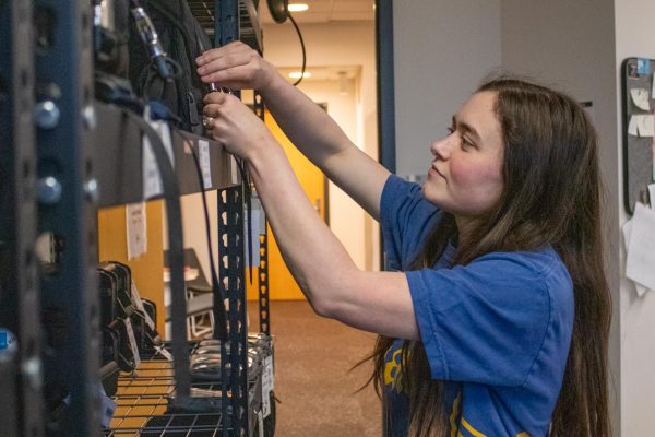 Megan Nichols checks camera bags at the Elliot School gear room. Nichols is graduating with a bachelor's in communication.
