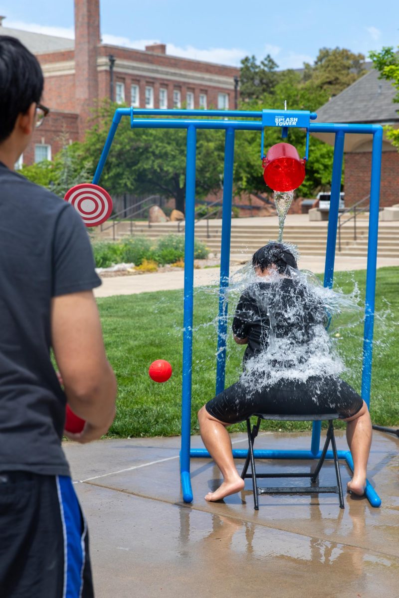 Nicholas Le is drenched in water by Jacob Inthirath at the Asian Student Conference's fundraising event outside the Rhatigan Student Center. The group sold Spam musubi, Thai tea and throws for a dunking station as part of an end-of-the-year fundraiser.