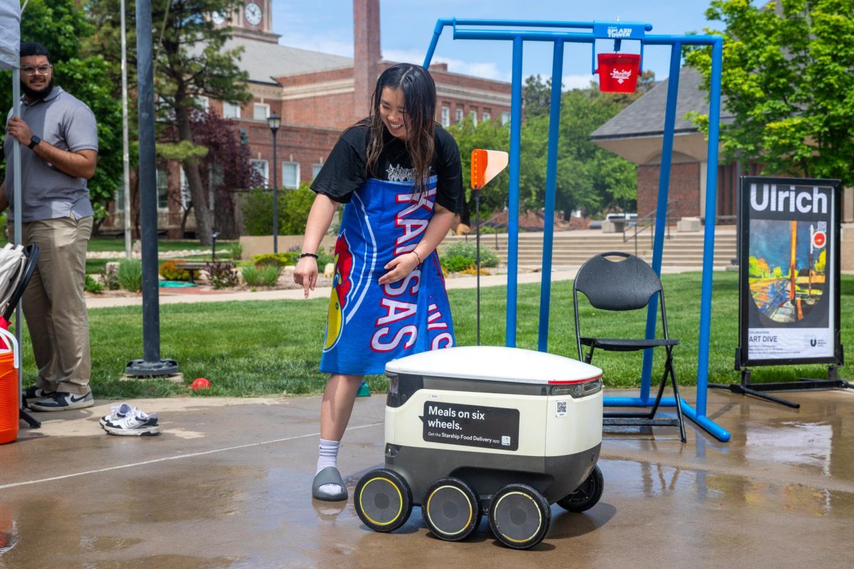 Megan Ta redirects a Starship delivery robot driving through the ASC's fundraising event outside the RSC.