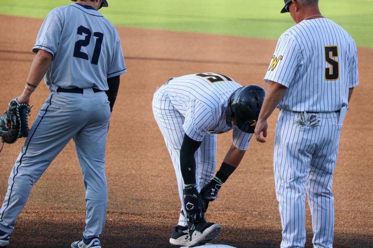 Senior Josh Livingston takes off his shin guard after hitting a single against Oral Roberts on May 13. Livingston went 2-5 at the plate in the 13-9 win.