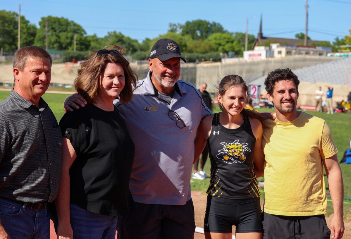 Senior Marissa Jensen and her family take a picture with WSU's Director of Track and Field Steve Rainbolt on May 9 during the senior day celebration. Jensen is a two-time NCAA West Preliminaries qualifier.