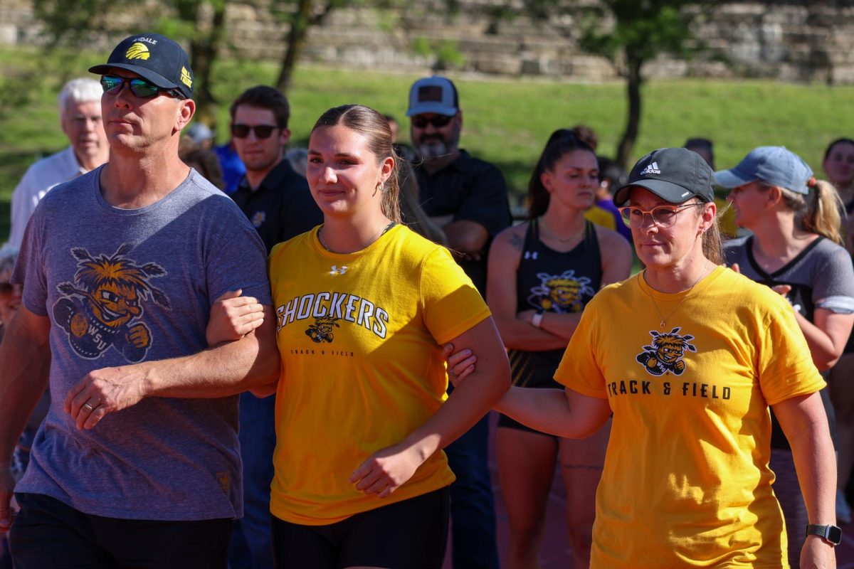Senior Samantha Marx walks with her family during the senior day celebration at the Shocker Open. Marx placed first and second, respectively, in the women's hammer throw and javelin on May 9.