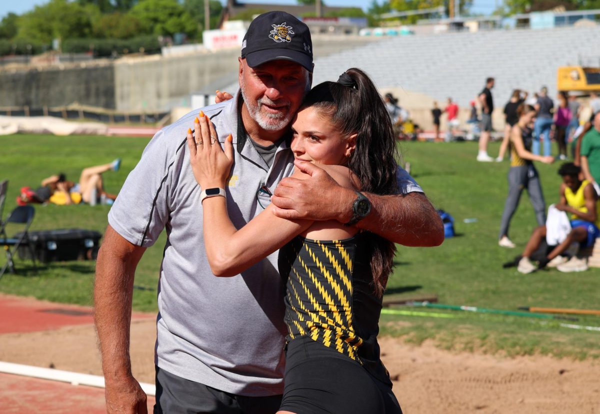 Senior Destiny Masters hugs WSU's Director of Track and Field Steve Rainbolt during the senior day celebration on May 9. Masters hit a mark of 5.84 meters in the women's long jump during the Shocker Open, good for first place.