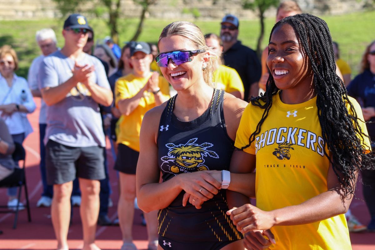 Senior Chidera Okoro walks out with her teammate Brianna Utecht during the senior day celebration at the Shocker Open on May 9. Okoro placed third in the women's triple jump with a mark of 11.44 meters.