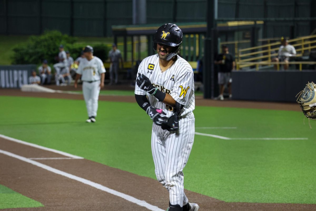 Senior Mauricio Millan takes off his elbow guard after being walked against Oral Roberts. Millan reached base once in the 13-9 win on May 13.