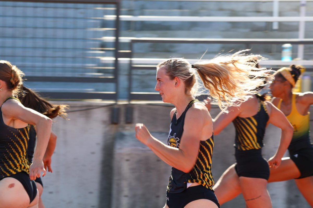 Junior Cali Kerschen's hair flies as she runs in the women's 100-meter hurdles on May 9. Kerschen finished in third place at the Shocker Open with a time of 14.00.
