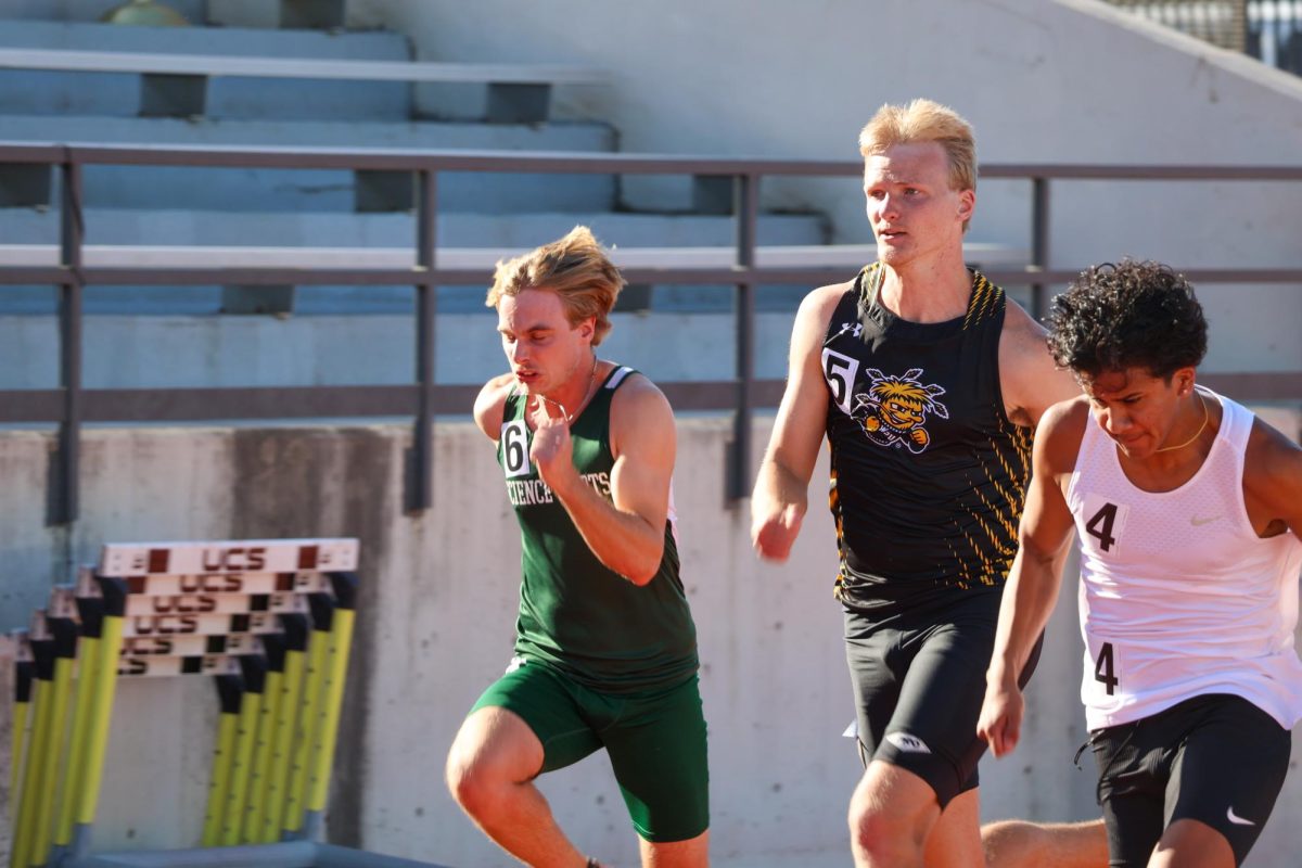 Senior Hudson Bailey sprints with two other competitors during the men's 100-meter at the Shocker Open. Bailey finished in 12th place with a time of 11.22 on May 9.