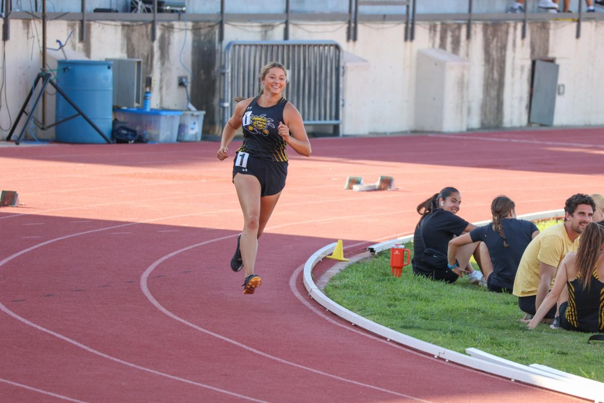 Junior Bailey Hartley smiles while running in the women's 400-meter. Hartley finished with a time of 1:28.71 at the Shocker Open on May 9.