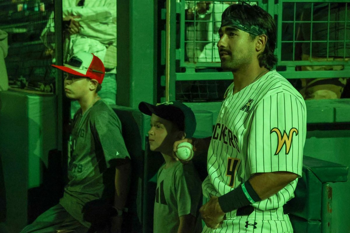 Senior Mauricio Millan watches the fireworks with two WSU baseball fans on May 13. The Shockers beat Oral Roberts, 13-9.