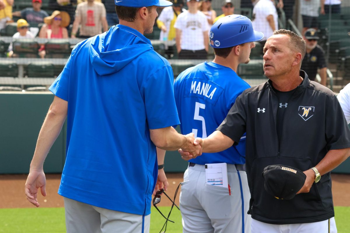 WSU head coach Brian Green shakes hands with the Memphis coaching staff on May 17. The 3-1 win on senior day gave Green his 301st win.