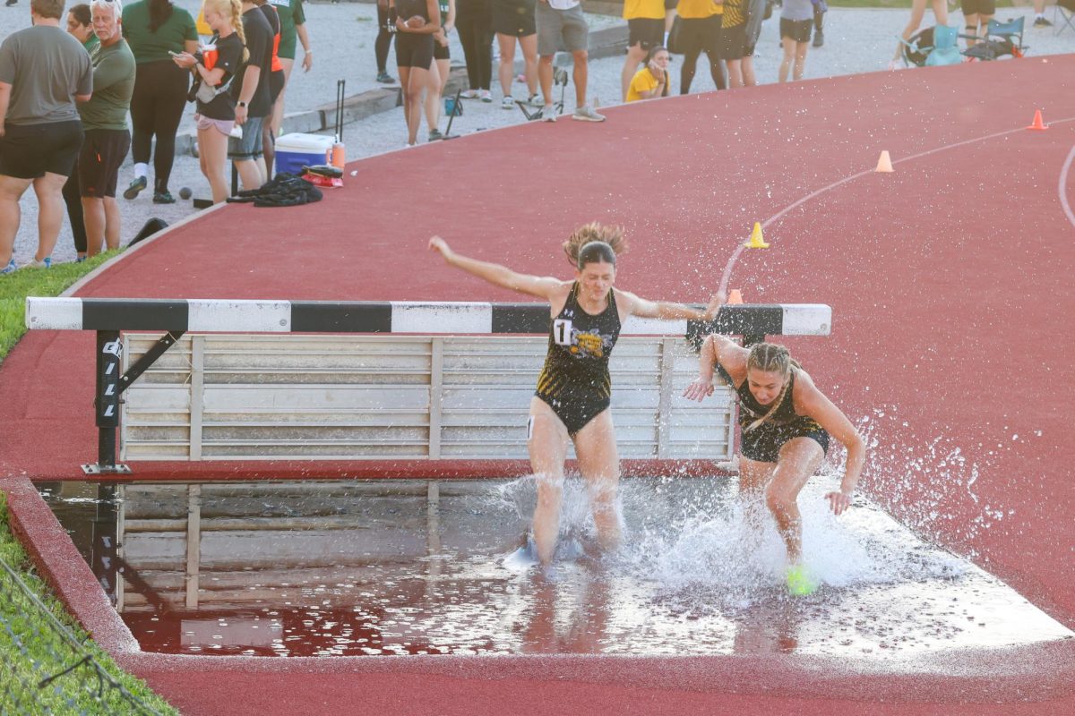 Sophomore Amanda Treptow and freshman Emily See splash into the water during the women's 3,000-meter steeplechase at the Shocker Open. Treptow and See were the only WSU athletes to race in the event on May 9.