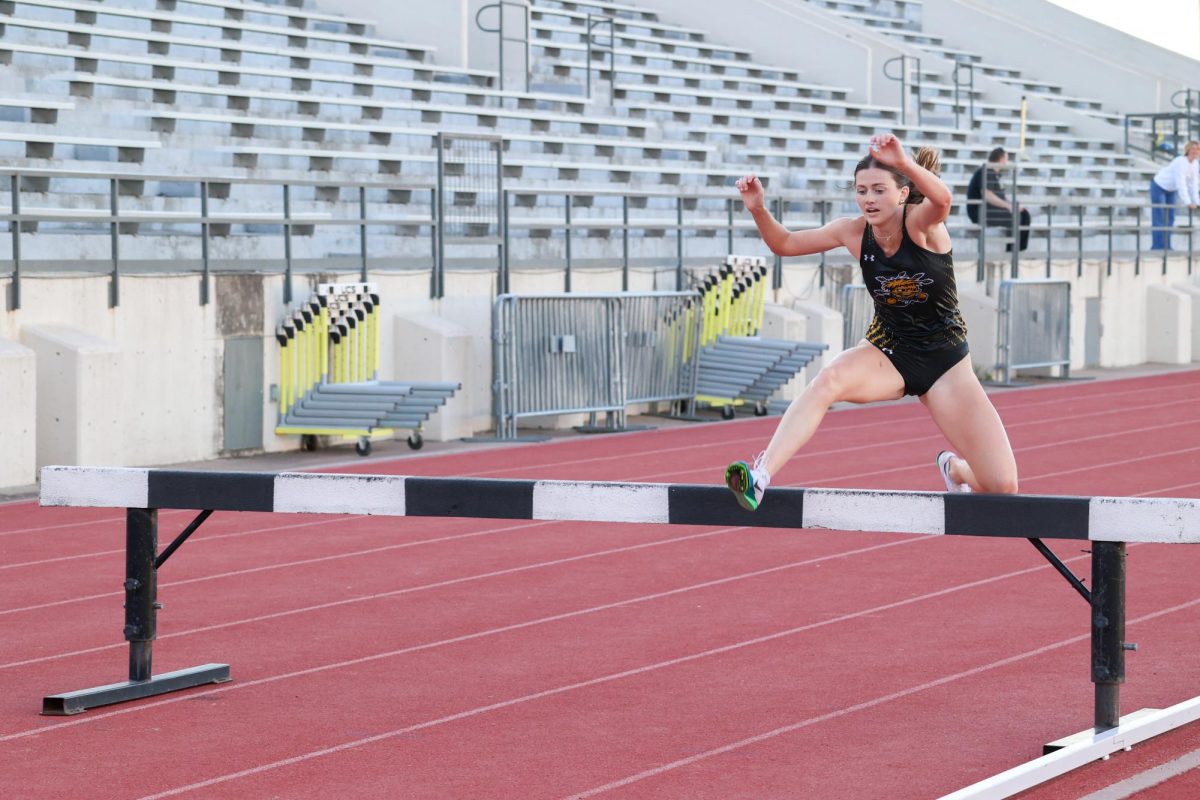 Sophomore Amanda Treptow jumps over a steeplechase barrier on May 9 during the women's 3,000-meter steeplechase. Treptow finished in first place at the Shocker Open with a time of 11:19.00.