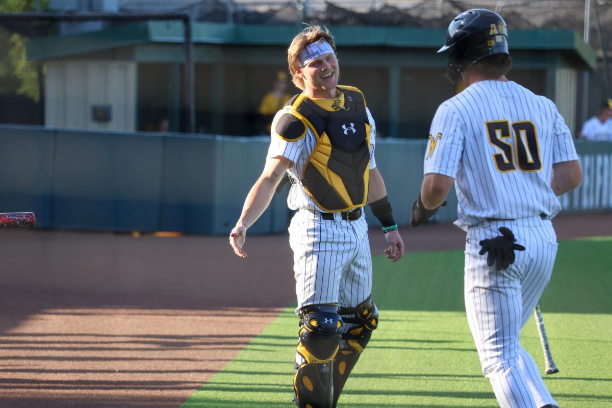 Senior Cole Dillon goes to high-five sophomore Kam Durnin after he scores a run on May 13. Durnin scored once in the 13-9 win against Oral Roberts.