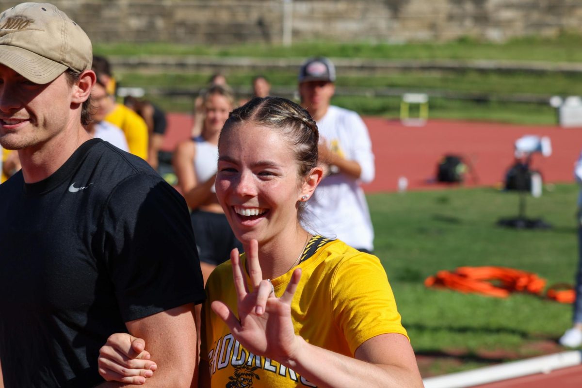 Senior Sydney Brown puts up WSU's hand sign while she walks out during the senior day celebration on May 9. Brown was on the winning women's 4x100 meter relay and placed third in the women's 200-meter sprint at the Shocker Open.