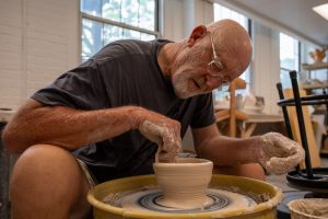 Rick Mullen shows how to make a bowl at the Build-A-Bowl for Empty Bowls event on June 18. Mullen The annual event took place at the Henrion Hall.