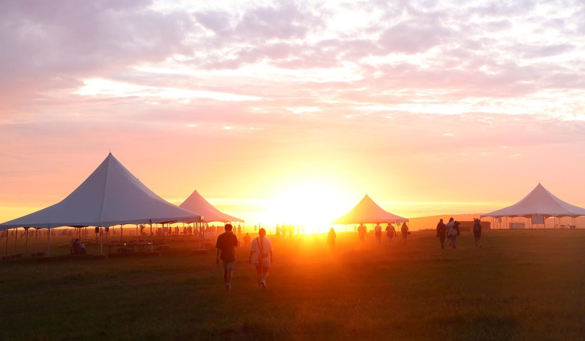 People rush and form a line to watch the sunset after the Symphony in the Flint Hills signature event concludes. Twenty years after the first one, early 8,000 people attended the final event. The nonprofit organization's mission is to educate people and bring appreciation to the prairies. / Flint Hills Media Project
