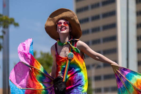 Participant waves huge fans with pride colors in it at the Wichita Pride Parade on June 28.