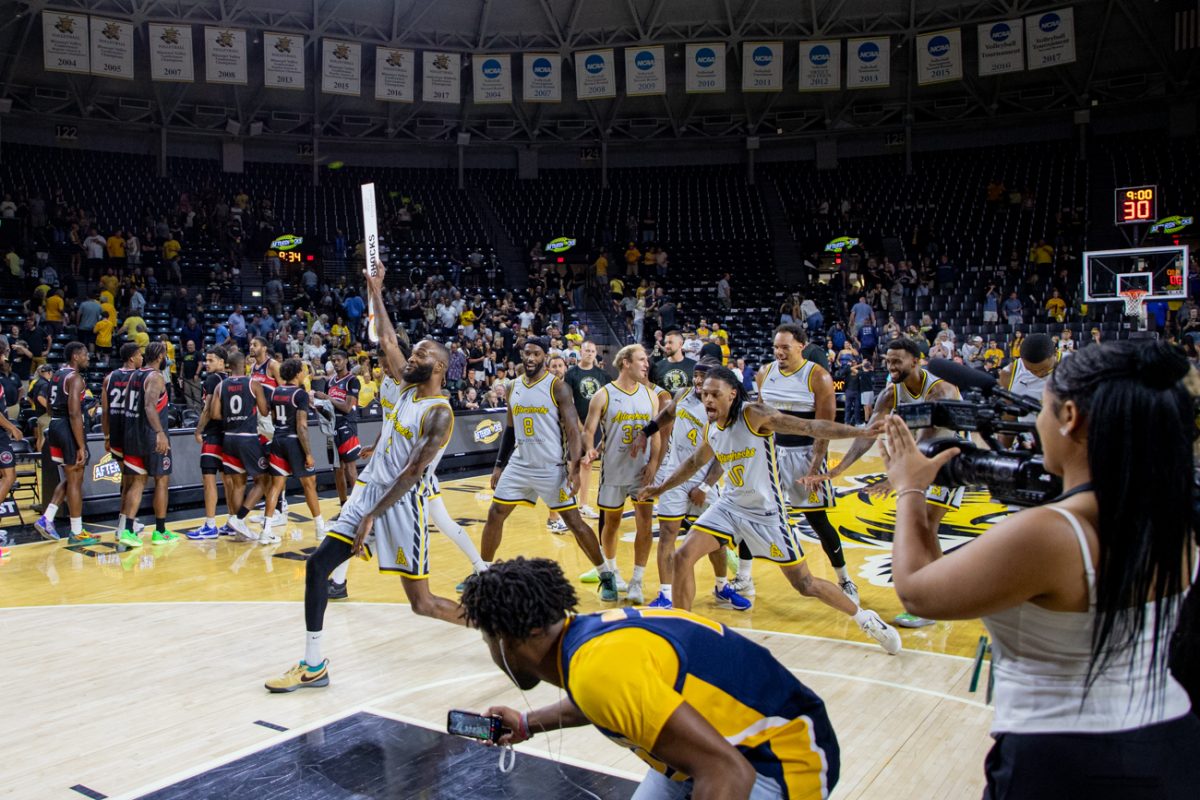 The AfterShocks celebrate at half court after a 74-51 win over No Excuses on July 18. The AfterShocks came into the tournament as the second seed in the Wichita Regional.