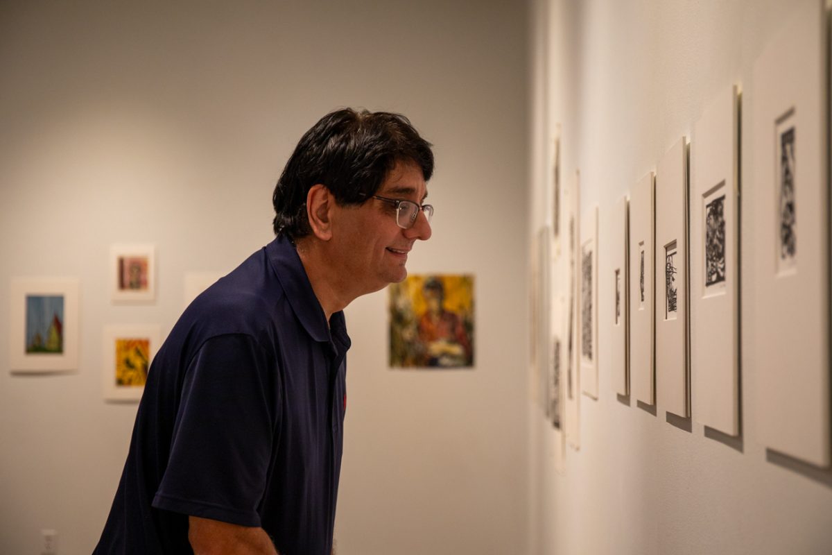 Bob Abraham looks at Clark Britton's art on Aug 7. Britton's art is currently exhibited at the Clayton Staples Gallery.