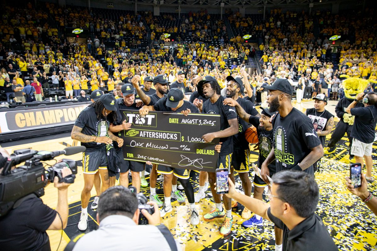 The AfterShocks pose for a picture with a check for $1 million after winning the championship game of The Basketball Tournament. The AfterShocks won six straight games to claim their title.