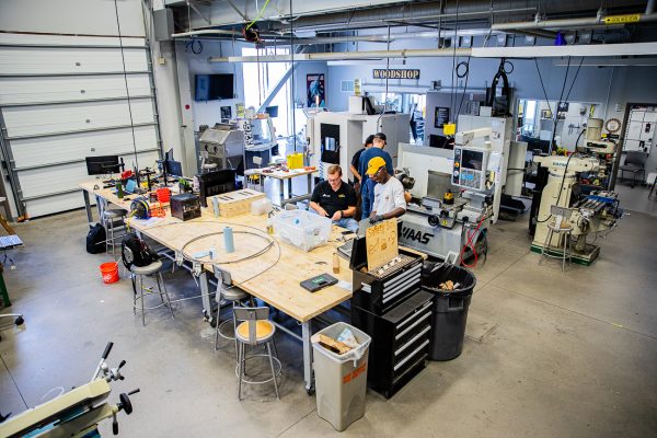 Students work on parts to repair a waterjet machine inside the Project Innovation Hub. The Lab was built in collaboration with Groover Labs, a Wichita-based nonprofit.