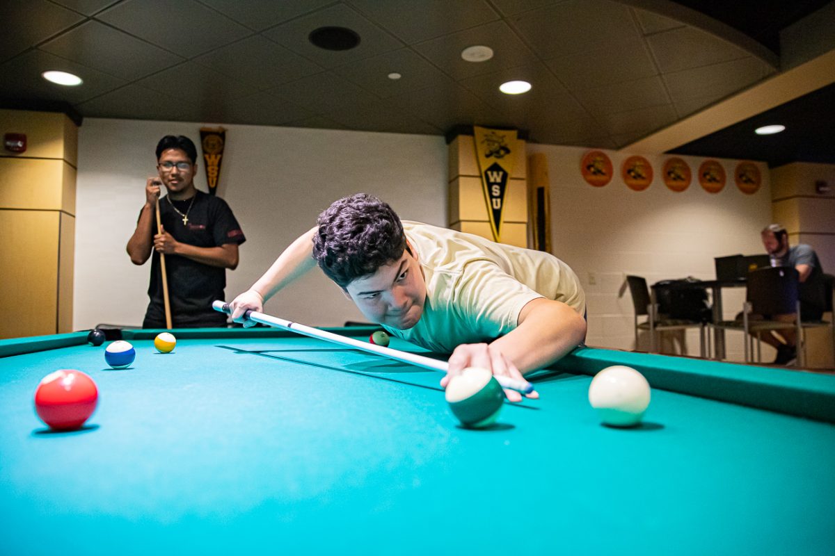 Junior David Bayas leans over to make a shot in billiards. RSC Day and Shocker Night had events throughout the RSC for 14 hours on Aug. 21.