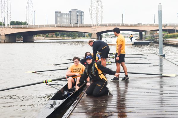 Junior coxwain Kelsey Cropper prepares students to row along the Arkansas River on Aug. 27. S'mores and Oars attendees had the opportunity to use the same boats as the Shocker Rowing team.