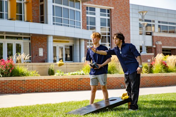 Freshmen Caiden Trione and Omar Mohamed compete in cornhole at the Belonging Bash. Cornhole, Connect 4, Spikeball, and Jenga were offered at the event.