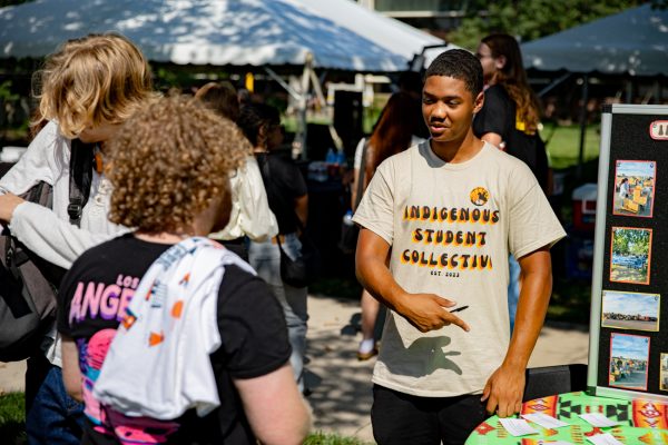 Sophomore Decson Chairs explains the Indigenous Student Collective to students at the Belonging Bash on Aug. 15. Various clubs and organizations tabled to introduce themselves to prospective members.