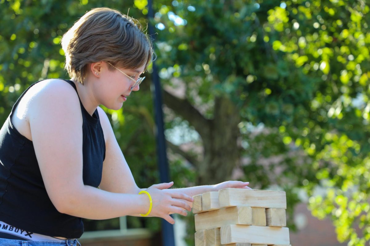 Freshman Grace Summers plays a game of Jenga at the mixer. The mixer was hosted by the student organization WHEAT. 