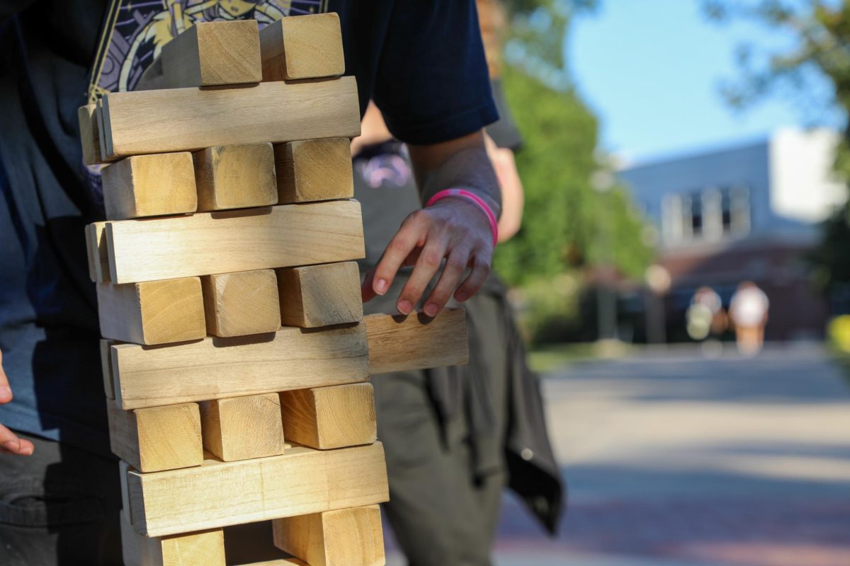 A student carefully pulls out a block in Jenga. Students played games after creating their mocktails on Aug. 21.