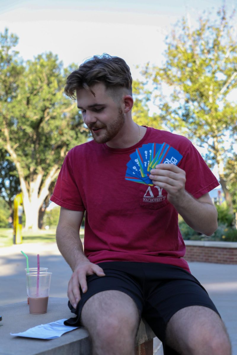 Junior Elliott Cotterill examines the rules for the card game Phase 10. Students played games like Phase 10, UNO and Apples to Apples at the event hosted by WHEAT on campus.