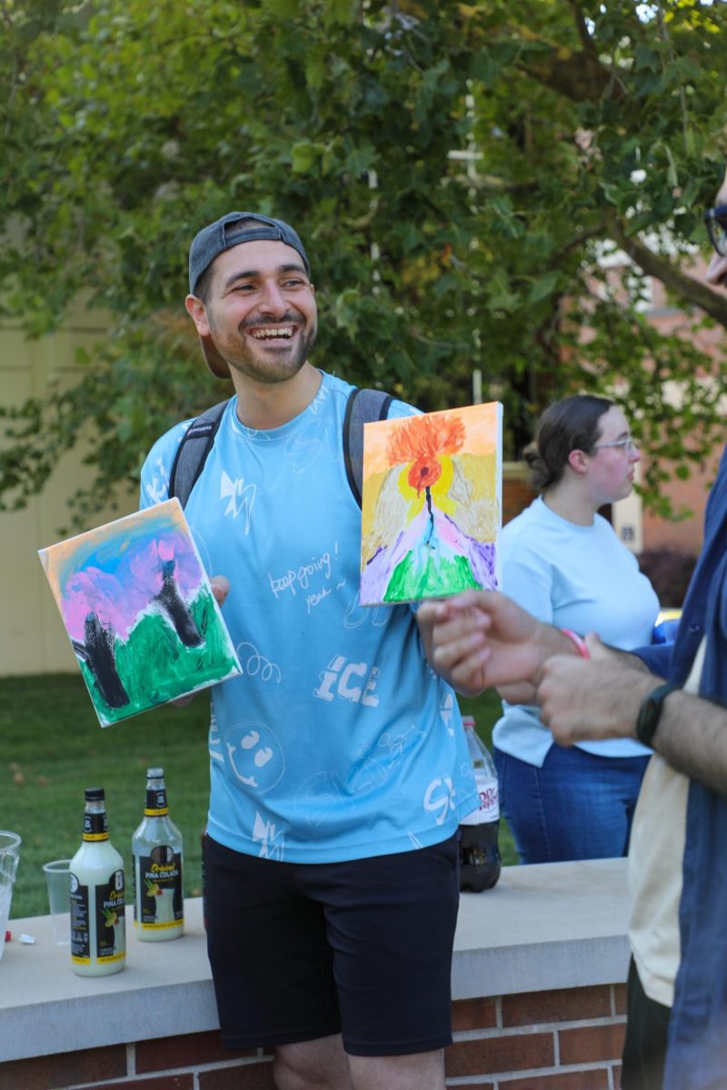Graduate student Omar Bakr showcases some artwork while having a conversation with fellow graduate student Afnan Gilal. 